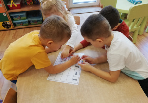 Dzieci w małych grupkach uczą się kodowania